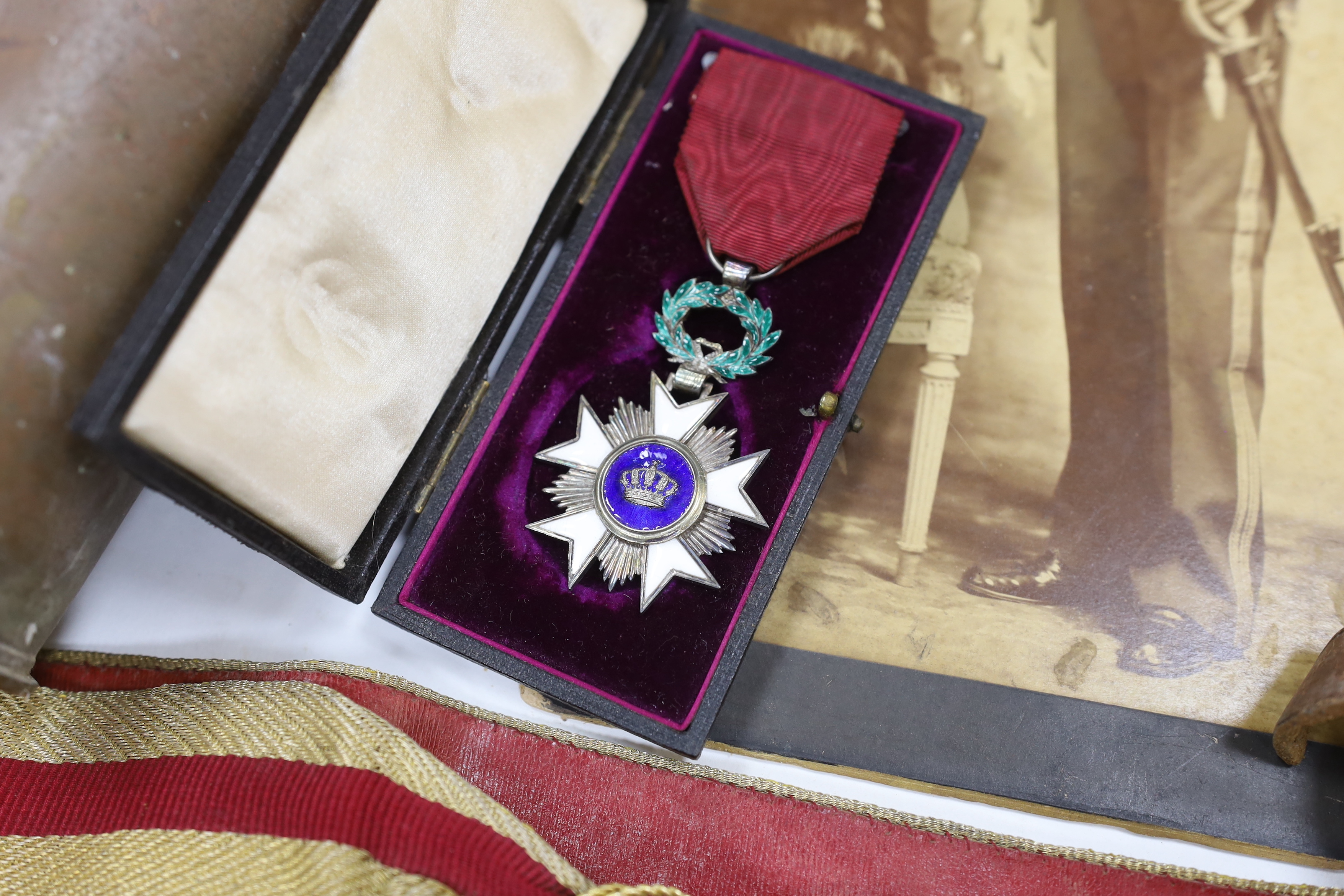 A late 19th century military sash with a related photograph showing the full uniform, a pair of Carl Zeiss binoculars, two compasses, a Belgium Order of the Crown cased medal, and a shell casing